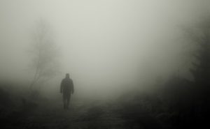person walking in dark fog like living apart from God. Believers live in the light