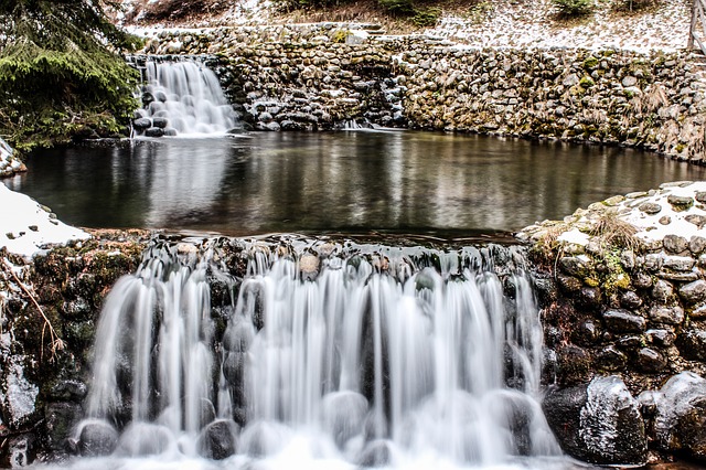 water pouring into one side of a small pool and pouring out on the opposite side